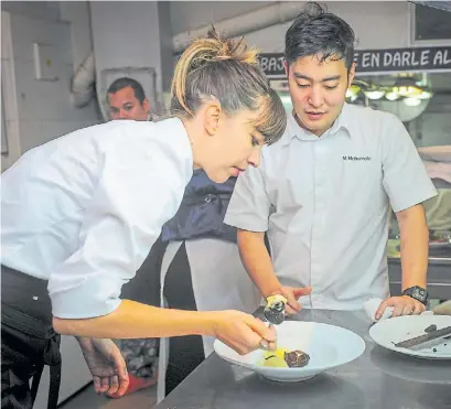  ??  ?? Equipo. Bajo la mirada de Maxi Matsumoto emplatan el postre con chocolate, mandarinas y merkén.