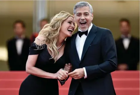  ?? GETTY IMAGES ?? Julia Roberts and George Clooney get a kick out of the red carpet at the Cannes Film Festival on Thursday.