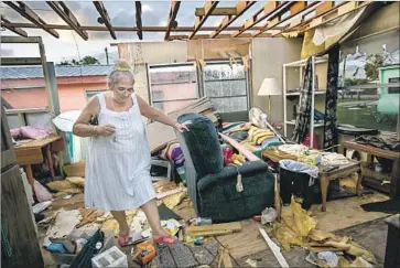  ?? Photograph­s by Marcus Yam Los Angeles Times ?? ALICE BARBER surveys her damaged trailer home in Immokalee, Fla. She escaped Irma with her 86-yearold mother. “I hope FEMA comes around,” she said. “But at least we all survived. And I have my mom.”