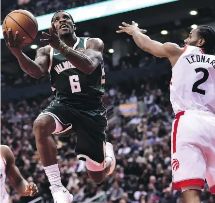  ?? FRANK GUNN/THE CANADIAN PRESS ?? Milwaukee Bucks guard Eric Bledsoe drives to the net past Toronto Raptors forward Kawhi Leonard Sunday at Scotiabank Arena as the visiting Bucks topped Toronto 104-99. It was Milwaukee’s second win this season against its Eastern Conference arch rival.