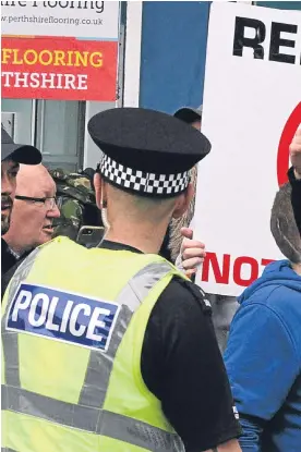  ??  ?? Top: police maintained a heavy presence in the city centre for the SDL ‘protest’ walk. Above: one of the counter-protesters.