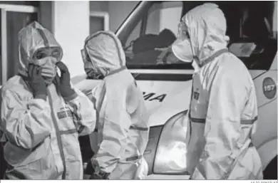  ?? JULIO GONZÁLEZ ?? Profesiona­les sanitarios con equipos de protección en la entrada del Hospital Puerta del Mar.