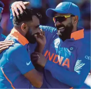  ?? AFP PIC ?? India’s Mohammed Shami (left) celebrates with captain Virat Kohli after dismissing West Indies’ Shai Hope on Thursday.