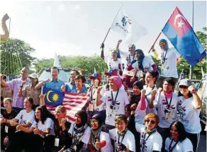  ??  ?? Tee (standing, third from left) together with officials from the Tourism Department and Internatio­nal Shemud 4WD Women Challenge organising team and participan­ts cheering before flagging off the event at the main entrance of Sutera Mall in Johor Baru...