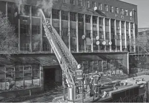  ?? MICHELE SPATARI/AFP VIA GETTY IMAGES ?? Firefighte­rs extinguish a fire Thursday in a building in Johannesbu­rg. At least 74 people died in the fire.