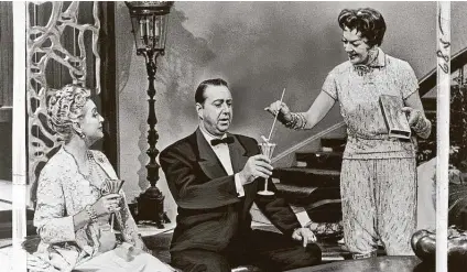  ?? Warner Bros. th ?? Rosalind Russell lights the alcohol in a “Flaming Mame” cocktail, a concoction for her guests, played by Lee Patrick and Willard Waterman, in “Auntie Mame,” part of tonight’s “Feel-Good Films: Family Ties” marathon on TCM.