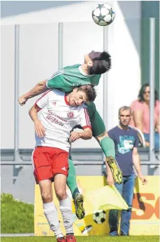  ?? FOTO: THOMAS WARNACK ?? Altheim Philipp Maier (grünes Trikot) setzt sich im Kopfballdu­ell gegen Bad Saulgaus Markus Berschauer durch.