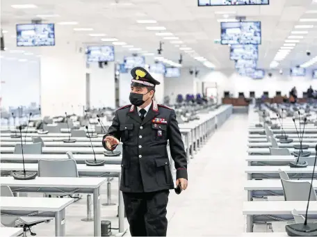  ?? PHOTO: YARA NARDI/REUTERS ?? High security: A Carabinier­e walks inside the specially built court room before the trial in Lamezia Terme, Italy, yesterday.