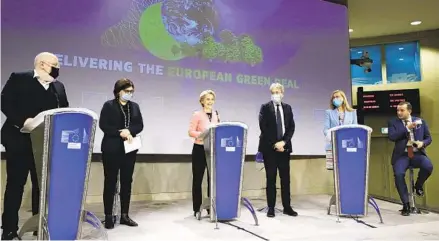  ?? VALERIA MONGELLI AP ?? European Commission President Ursula von der Leyen (center) speaks during a news conference at EU headquarte­rs in Brussels on Wednesday as the EU unveils sweeping new legislatio­n to help meet its pledge to cut emissions by 55 percent over the next decade.