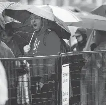  ?? DARREN BROWN ?? A man yawns in a long security check lineup during rainy Canada Day celebratio­ns downtown on July 1.