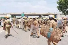  ?? AFP ?? Police officials run towards protesters in Tuticorin, some 600 kilometres south of Chennai, on Tuesday.