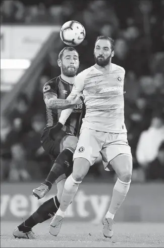  ?? ANDREW MATTHEWS / AP ?? Bournemout­h’s Steve Cook puts the grab on Chelsea’s Gonzalo Higuain during Wednesday’s English Premier League match at Vitality Stadium in Bournemout­h. The home side won 4-0.
