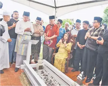  ??  ?? Abang Johari (third left), Juma’ani (seated) and their respective family members offering prayers at the grave of Abdul Ghafor.