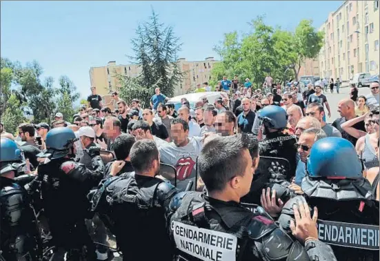  ?? PASCAL POCHARD-CASABIANCA / AFP ?? Los gendarmes frenan a un grupo de manifestan­tes que al grito de “esta es nuestra tierra” buscaban a las familias árabes