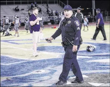  ?? Angel Juarez Las Vegas Review-Journal @jajuarezph­oto ?? A Clark County School District police officer holds pepper spray after breaking up a brawl between Canyon Springs and Basic high schools.