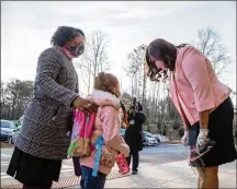  ?? ALYSSA POINTER/AJC 2021 ?? John R. Lewis Elementary School principal Lashawn Mcmillan (right) greets students as they are dropped off for the first day of in-person learning March 9. Dekalb is the fifth district in the metro area to relax its mask policy.