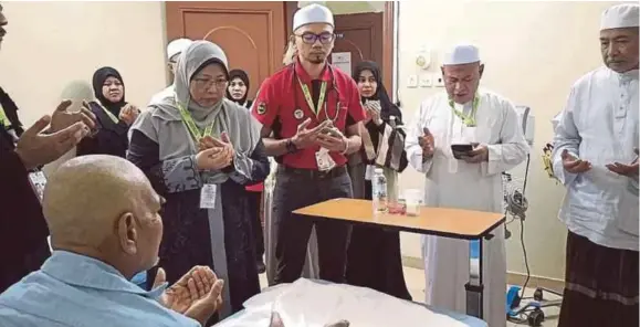  ?? (Foto Ihsan TH) ?? Fuziah bersama petugas TH berdoa ketika melawat pesakit di Pusat Rawatan TH Syisyah, Makkah, semalam.