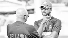  ??  ?? Dinesh Chandimal (right) has a chat with head coach Chandika Hathurusin­gha. - AFP photo