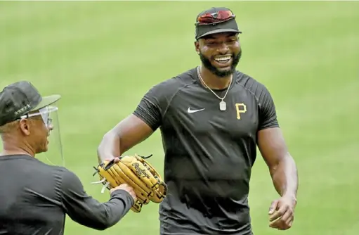  ?? Matt Freed/Post-Gazette ?? Gregory Polanco greets third-base coach Joey Cora during a workout last week at PNC Park. Polanco is at least the third Pirates player to test positive for COVID-19. “He’s doing well,” manager Derek Shelton said, although a timetable for his return is uncertain.