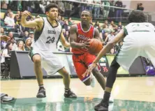  ?? Gabrielle Lurie / The Chronicle 2017 ?? St. Ignatius’ Darrion Trammell (center) drives past Sacred Heart’s Nathan Robinson (left) during a game last January.