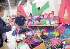  ?? MARLA BROSE/JOURNAL ?? Lawrence Chacon, an instructio­nal coach from Kirtland Elementary School, picks up a load of backpacks and school supplies collected and donated by the Alpha Kappa Alpha sorority, which is holding its annual South Central Regional Conference at the...