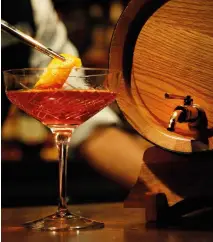  ??  ?? French and American oak barrels displayed at Barong Bar, barrel-aged Negroni cocktail