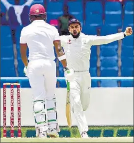  ?? AP PHOTO ?? Virat Kohli exults after the dismissal of Darren Bravo, who was caught behind just before lunch.