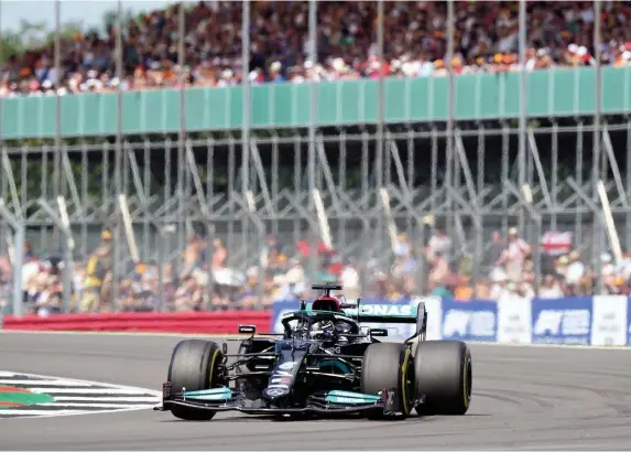  ?? Tim Goode/PA ?? > Lewis Hamilton passes in front of packed stands at the British Grand Prix prior to securing pole position for today’s inaugural Formula One sprint race at Silverston­e. Max Verstappen is second, while Hamilton’s fellow Britons Lando Norris and George Russell will start sixth and eight respective­ly