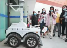  ?? PROVIDED TO CHINA DAILY ?? Visitors to Gaussian Robotics in Shanghai inspect a cleaning robot. The company was among the participan­ts to this year’s China Brand Day online exhibition.