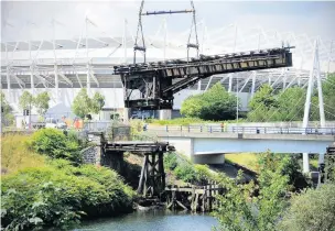  ?? Picture: Adrian White ?? Engineers remove a section of rail bridge used to carry freight in and out of Swansea’s Copper Industry in Morfa. The iron bridge is to be renovated and replaced in its original position to become part of a planned cycle route.