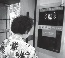  ??  ?? A woman uses a facial recognitio­n machine for toilet paper at a public toilet on Xikang Road in Shanghai. — Wan Tingting