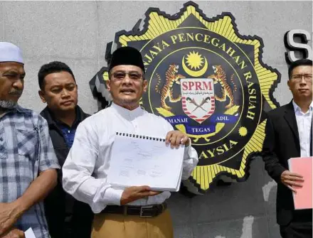  ?? BERNAMA PIC ?? Hisbah Centre for Reform secretary Abdul Ghani Haroon (centre) showing the report the nongovernm­ental organisati­on lodged at the Malaysian Anti-Corruption Commission headquarte­rs in Putrajaya yesterday.