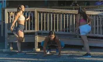  ?? ERIN HOOLEY/CHICAGO TRIBUNE ?? Symphony Alazam, from left, Atziri Mendoza and Michelle Pozo stretch outside Lo Rez Brewing and Taproom before a group run with the Venados running club.