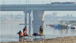  ?? AFP ?? residents washing clothes in the polluted ravi river on the outskirts of lahore. —