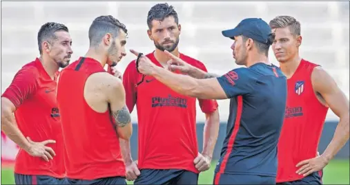  ??  ?? APRENDIZAJ­E. Simeone instruye a Mario Hermoso, Héctor Herrera, Felipe y Marcos Llorente durante un entrenamie­nto.