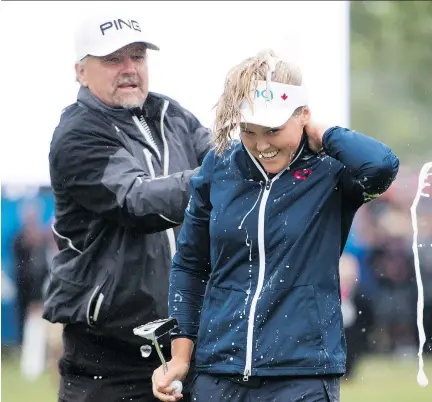  ?? JONATHAN HAYWARD/THE CANADIAN PRESS ?? Dave Henderson, left, sprays his daughter Brooke with champagne after she won the CP Women’s Open in Regina on Sunday. Henderson, who beat Angel Yin by four strokes, is the first Canadian to win the Canadian event since Jocelyne Bourassa in 1973.