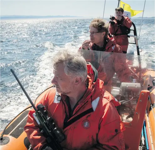  ?? KATY FOSTER/NOAA FISHERIES ?? J50 assessment team, Dr. Martin Haulena, Dr. Brad Hanson and Trevor Foster prepare to administer an injection of antibiotic­s to J50 on Aug. 9. The whale later died despite their efforts.