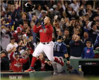  ?? NAncy lAnE PHOTOS / HErAld STAFF ?? WINNING FEELING: Christian Vazquez celebrates his game-winning home run in the 13th inning by tossing his helmet before crossing home plate as the Red Sox won Game 3 of the ALDS 6-4.
