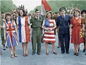  ??  ?? Young women clothe themselves in dresses representi­ng the flags of the four victorious allies as Paris celebrates Victory in Europe on May 8 1945