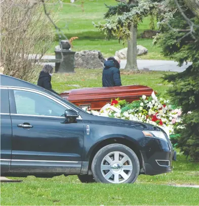  ?? FRANK GUNN / THE CANADIAN PRESS ?? Mourners maintain physical distancing as they pay respects at a funeral in Toronto on Tuesday. Many families are
now opting to cremate their loved ones and putting off formal ceremonies until after the lockdown is over.