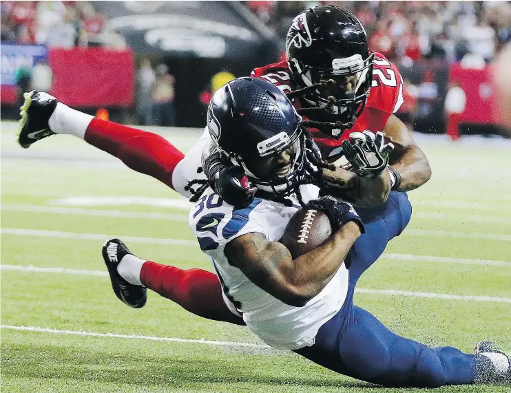  ?? — AP FILES ?? Seattle Seahawks running back J.D. McKissic is tackled by Atlanta safety Keanu Neal Saturday during the Falcons’ 36-20 playoff victory at the Georgia Dome.