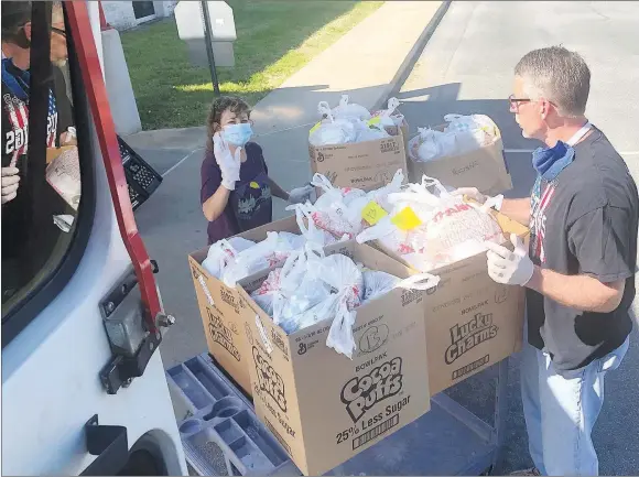  ?? RICK PECK/SPECIAL TO MCDONALD COUNTY PRESS ?? Noel Primary principal Debbie Pearson and bus driver Lee Smith load meals for that day’s delivery.