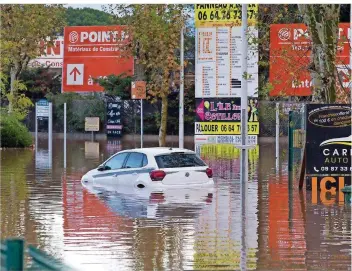  ?? FOTO: DANIEL COLE/DPA ?? Ein Auto steht halb versunken im Hochwasser in Fréjus. In der Hafenstadt im südfranzös­ischen Départemen­t Var kam eine Frau ums Leben, nachdem sie von den Wassermass­en mitgerisse­n worden war.