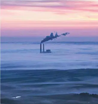  ?? ANDREW BURTON GETTY IMAGES / AGENCE FRANCE-PRESSE ?? Une centrale au charbon du Dakota du Nord, noyée dans des brumes matinales en 2013. Les ÉtatsUnis sont les deuxièmes plus gros émetteurs de la planète (18% du total), mais sont champions mondiaux pollueurs par habitant: un Américain émet 22,5 tonnes de...