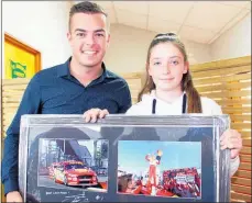  ?? Photo / Cathy Asplin ?? Novice karter Louise Rawson (13), bankrolled by her father Glenn, had the top bid for the Scott McLaughlin framed photos. Scott provided a handwritte­n message of encouragem­ent on the back of the frame and threw in two tickets to watch racing at Pukekohe.