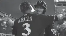  ?? MORRY GASH/AP ?? The Brewers’ Yasmani Grandal is hugged by Orlando Arcia after a sixth-inning homer.