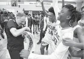  ?? PAUL W. GILLESPIE/CAPITAL GAZETTE ?? Meade coach Mike Glick, left, celebrates with his team after an 82-76 win over Northwest on Friday night in the MPSSAA Class 4A state quarterfin­als.