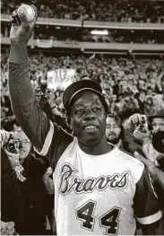  ?? Associated Press file photo ?? Aaron holds the ball he hit for his 715th home run, one of the most memorable moments in baseball history.