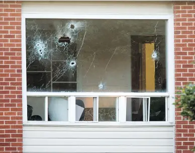  ?? ANDREW VAUGHAN / THE CANADIAN PRESS ?? Bullet holes riddle a window in an apartment building in Fredericto­n after a shooting spree last Friday that left four people dead, including two city police officers. Residents of the building began returning to their homes on Tuesday.