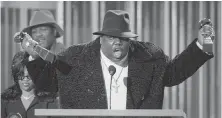  ??  ?? Notorious B.I.G. clutches his awards for rap artist and rap single of the year during the Billboard Music Awards in New York in 1995.
